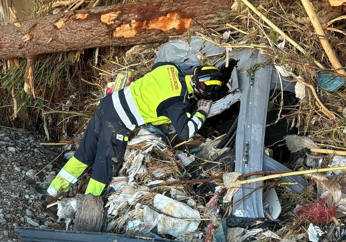 Un bombero de la Diputación de Valladolid inspecciona el interior de un vehículo tras los efectos de la DANA.