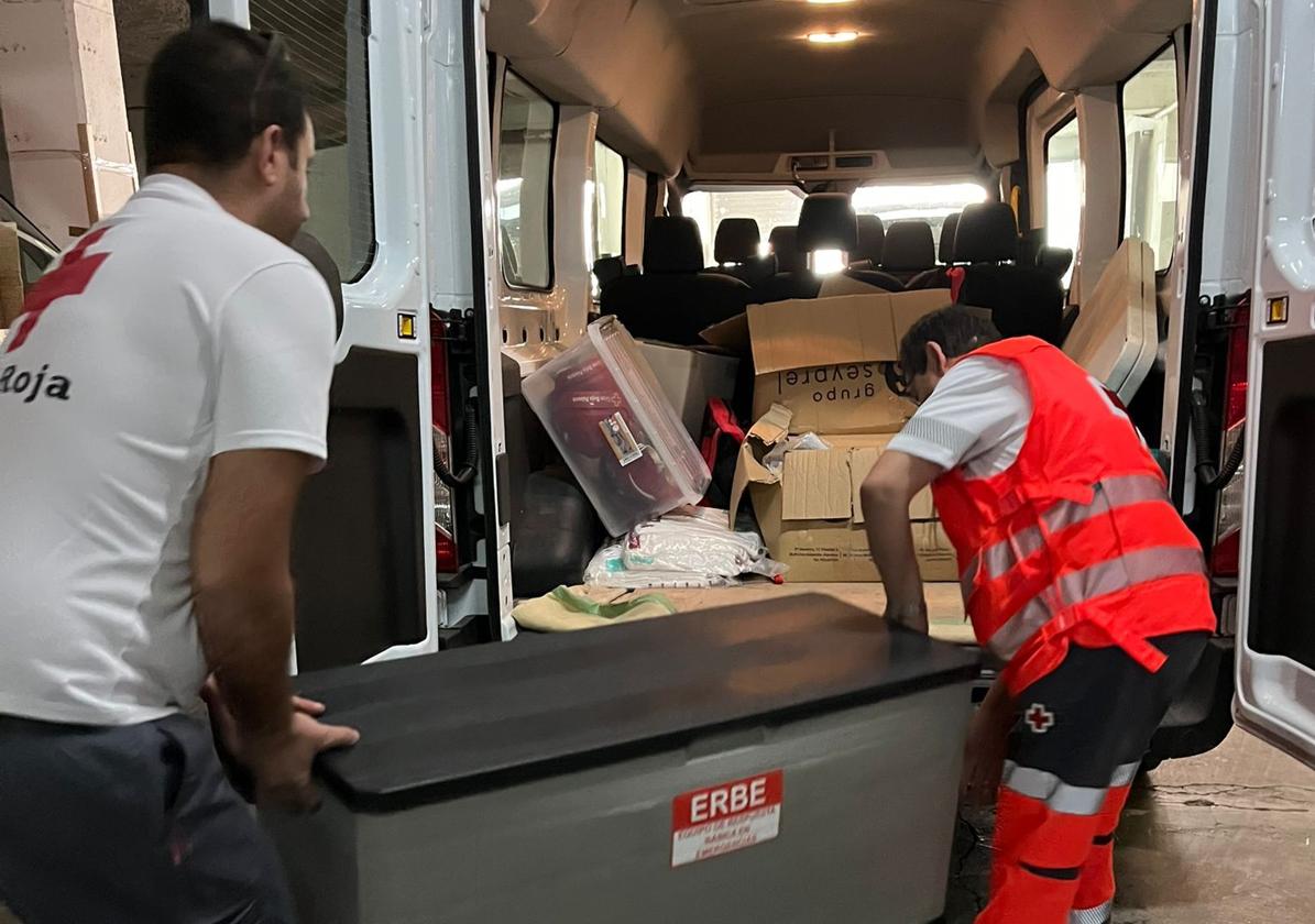 Voluntarios de Cruz Roja cargan una furgoneta con ayuda para los damnificados de la DANA.