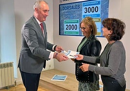 El alcalde entrega los primeros dorsales a las representantes de Cruz Roja y Cáritas.