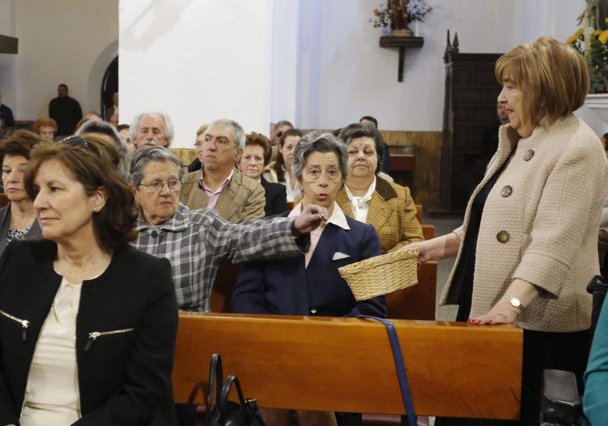 Una mujer pasa el cepillo durante una eucaristía.