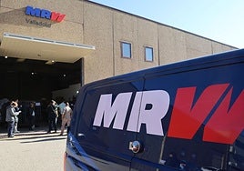 Clientes de MRW esperando para recoger sus paquetes en la calle Aluminio del polígono San Cristóbal.