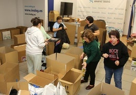 Voluntarias participan en la clasificación y empaquetado de productos para su envío a Valencia.