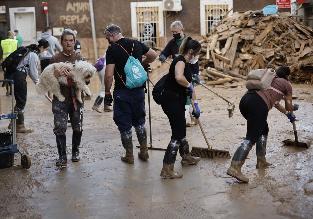 Voluntarios ayudan en la limpieza de una calle de Paiporta (Valencia).