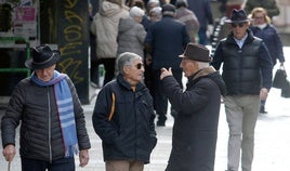 Varias personas caminan y conversan en una calle del centro de la capital.