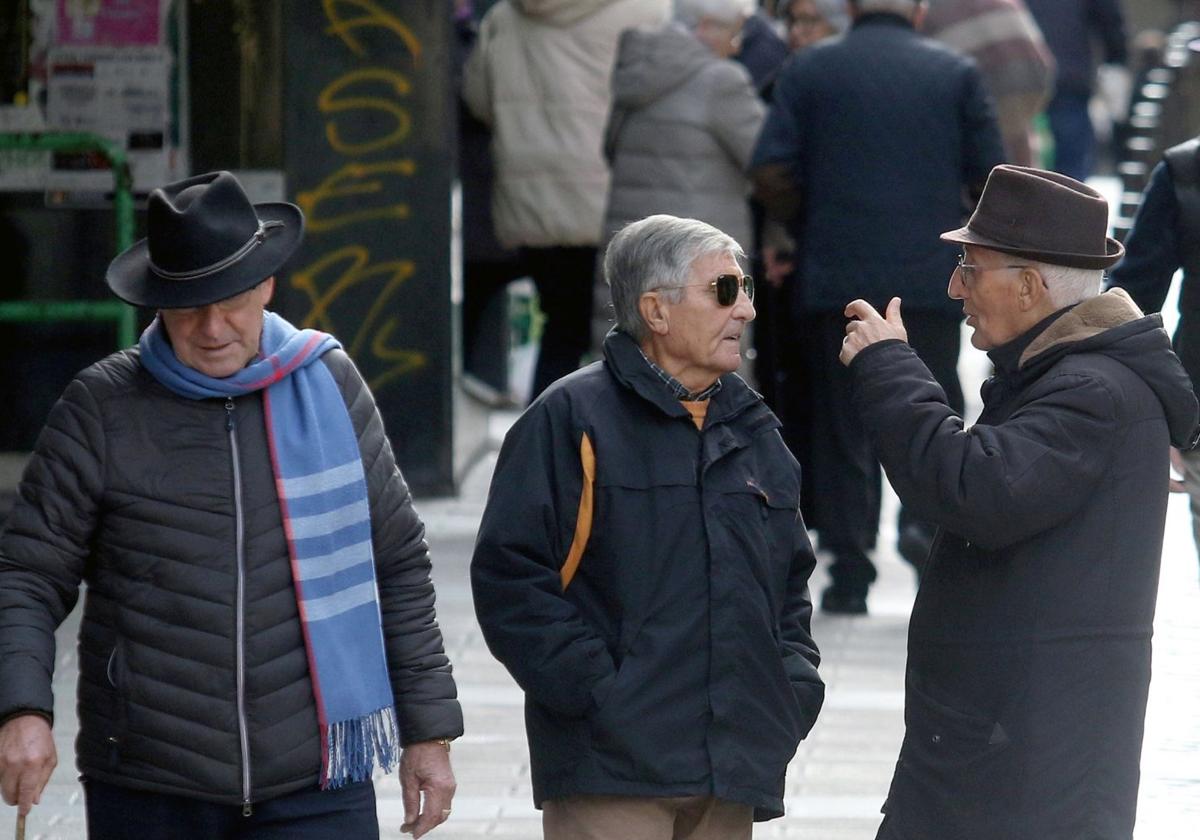 Varias personas caminan y conversan en una calle del centro de la capital.