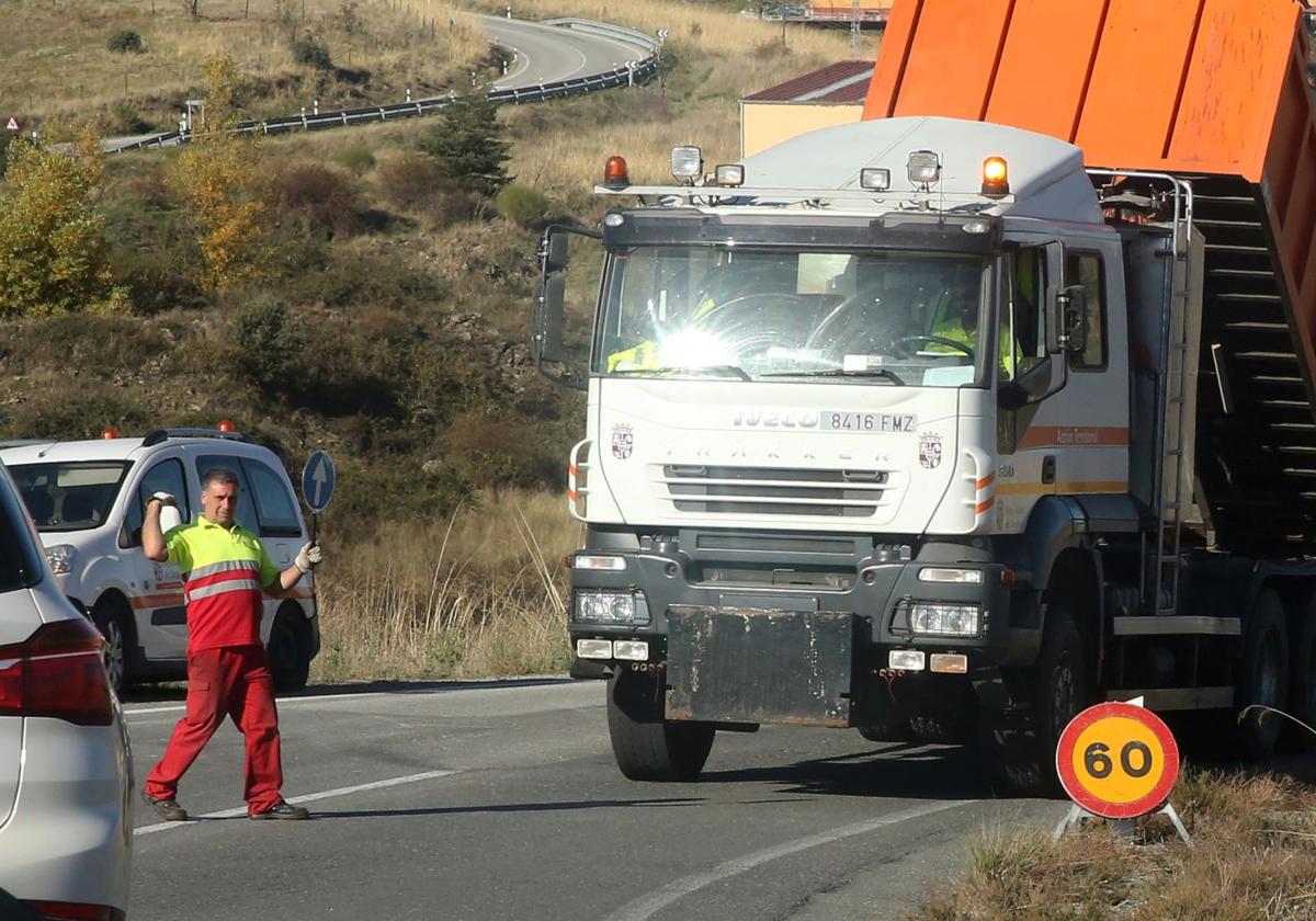 Un operario regula el tráfico para facilitar las obras de mejora en una carretera de la provincia de Segovia.