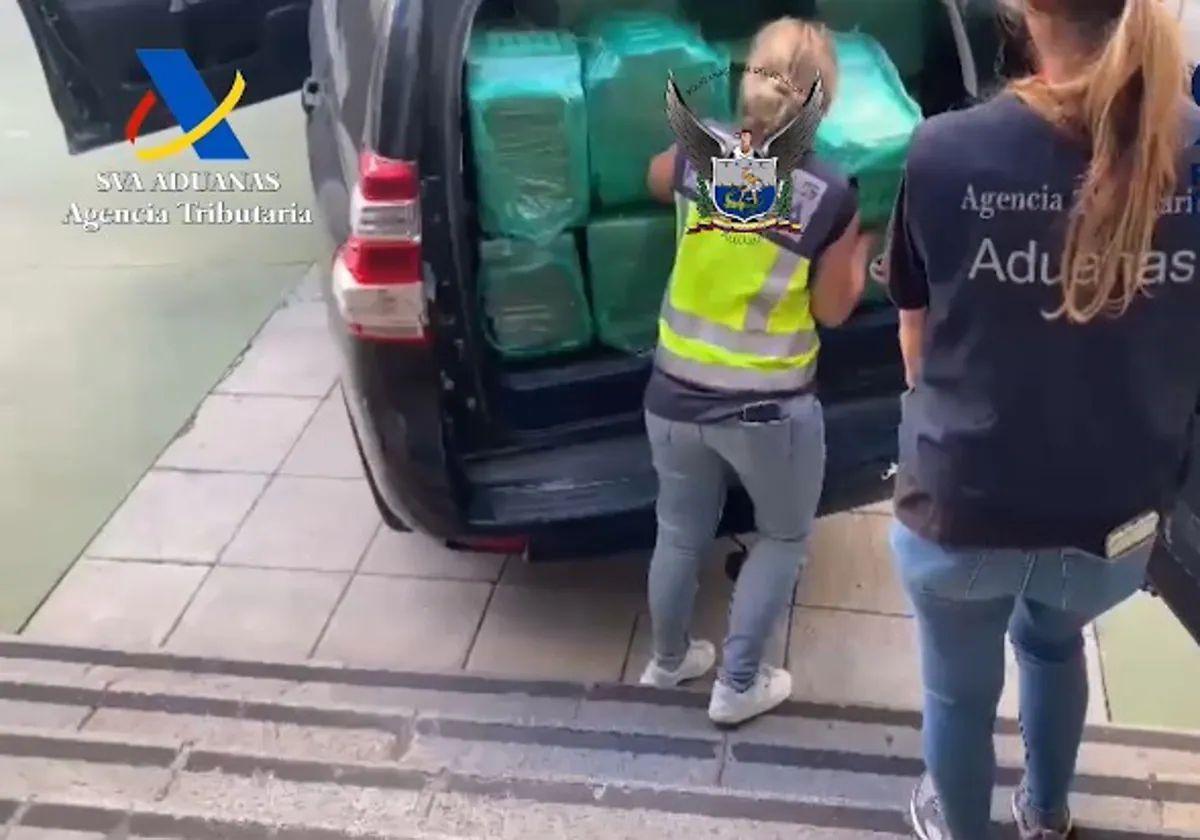 Agentes de Policía y Vigilancia Aduanera transportan el último alijo de coca cuya entrada facilitó el mando.