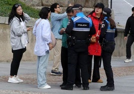 Agentes de la Policía Local atienden a turistas que han sufrido un robo en la plaza del Azoguejo.