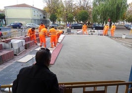 Un hombre observa los trabajos de urbanización de la plaza del Marqués de Suances desde la terraza del bar que ocupa su espacio central.