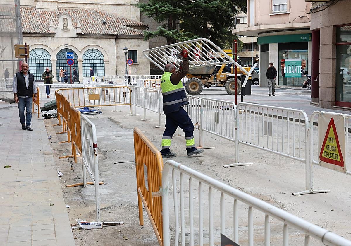 Un trabajador de DH Ecoenergías retira vallas de la calle San Juan de Dios.