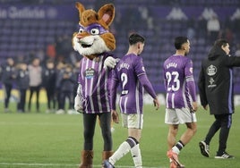 Luis Pérez y Anuar se retiran del campo consolados por la mascota del club.