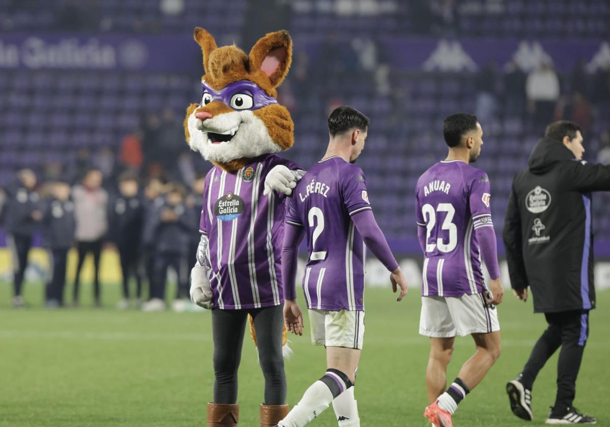 Luis Pérez y Anuar se retiran del campo consolados por la mascota del club.