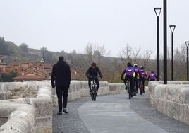 Peatones y ciclistas pasan por el renovado puente de Simancas a primera hora de la mañana de este viernes.