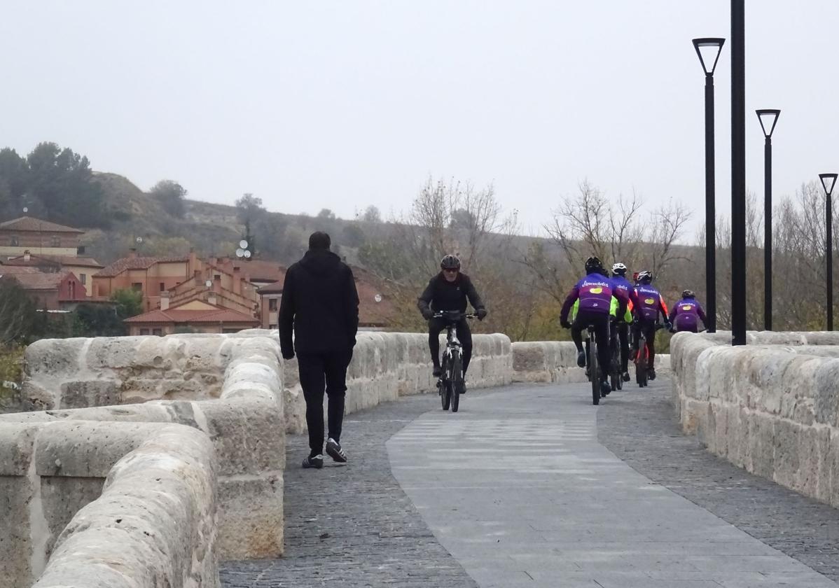 Peatones y ciclistas pasan por el renovado puente de Simancas a primera hora de la mañana de este viernes.