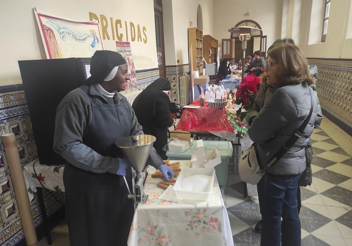 sor INés rellena los canutillos de las Brígidas de Paredes de Nava, este viernes en la feria Dulzura en Clausura,