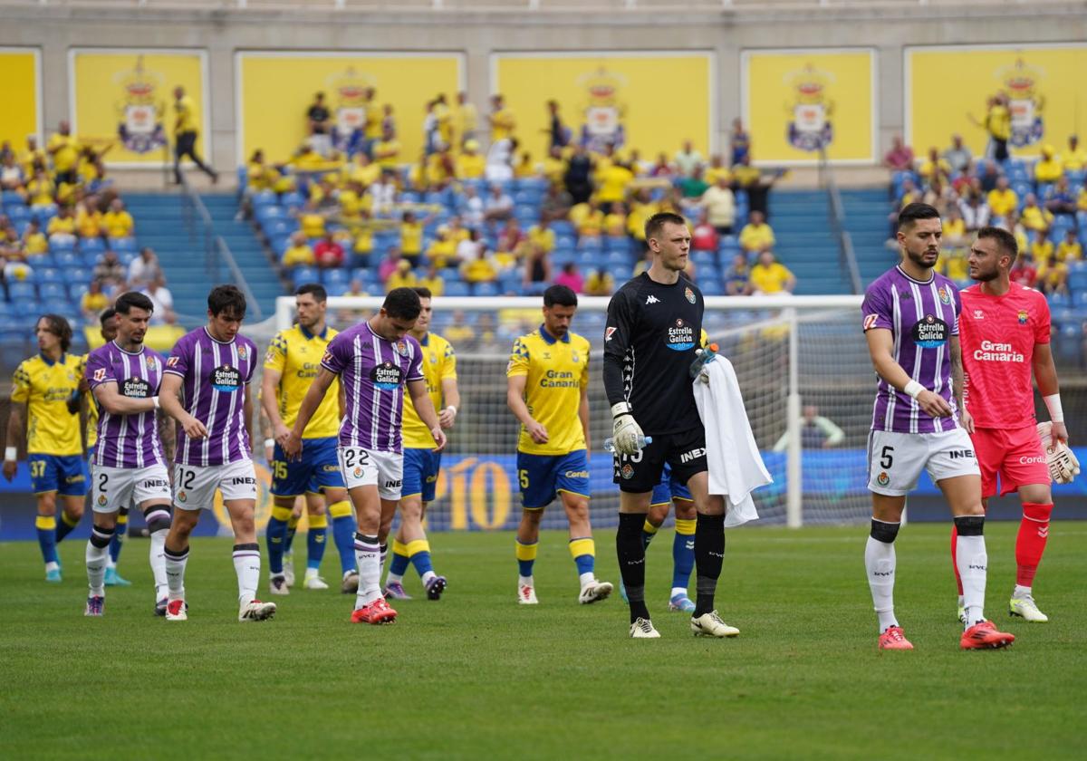 Los jugadores de Real Valladolid y Las Palmas se encaminan al centro del campo.