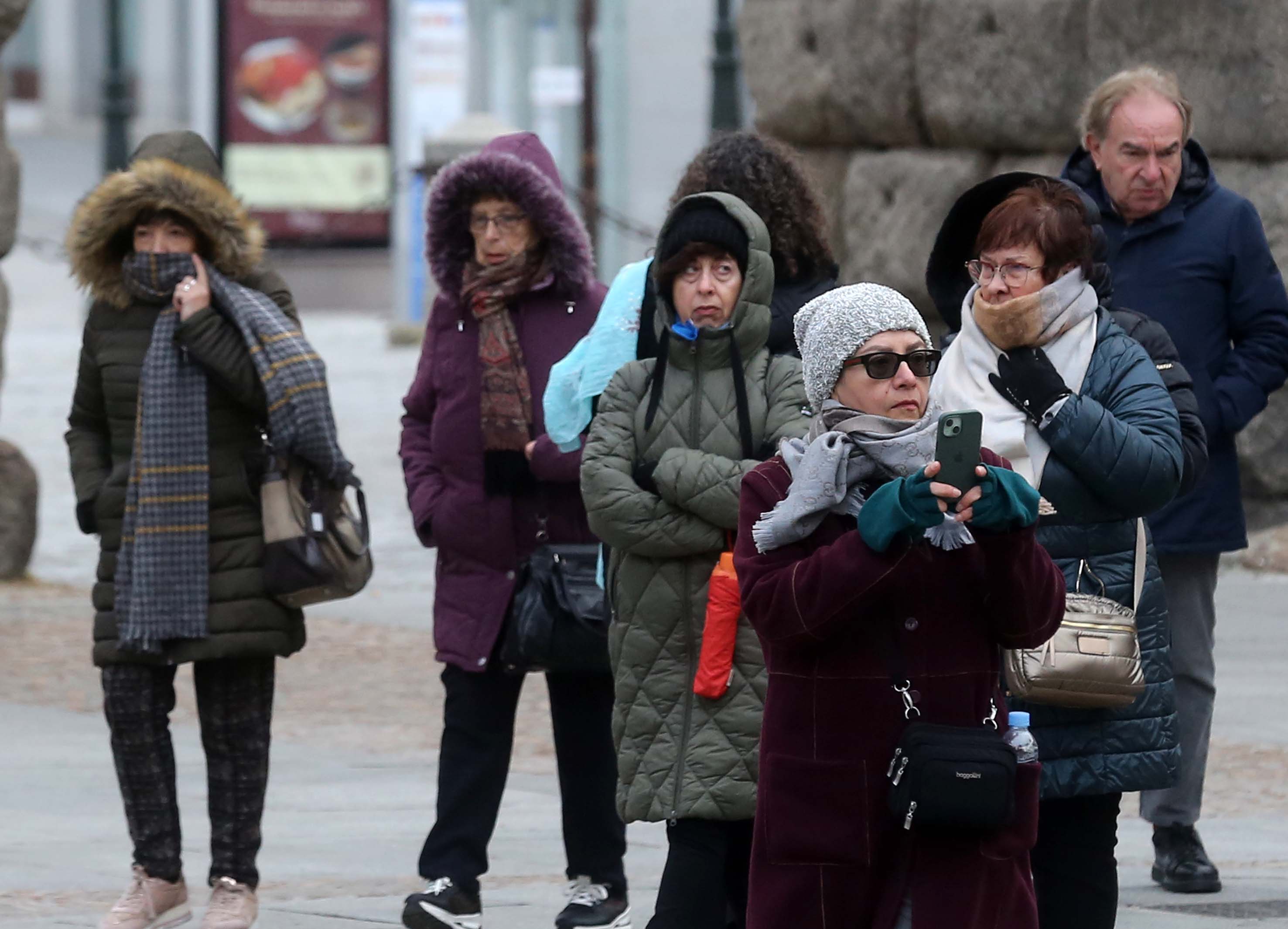 Turistas abrigados a primera hora de este lunes en Segovia capital.