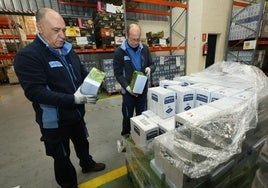 Dos voluntarios del Banco de Alimentos preparan víveres en su nave del polígono de Argales.