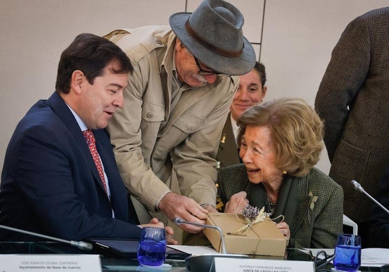 Eudald Carbonell entrega a doña Sofía un ejemplar de la edición 'Sierra de Atapuerca. Una mirada botánica' en presencia de Fernández Mañueco.