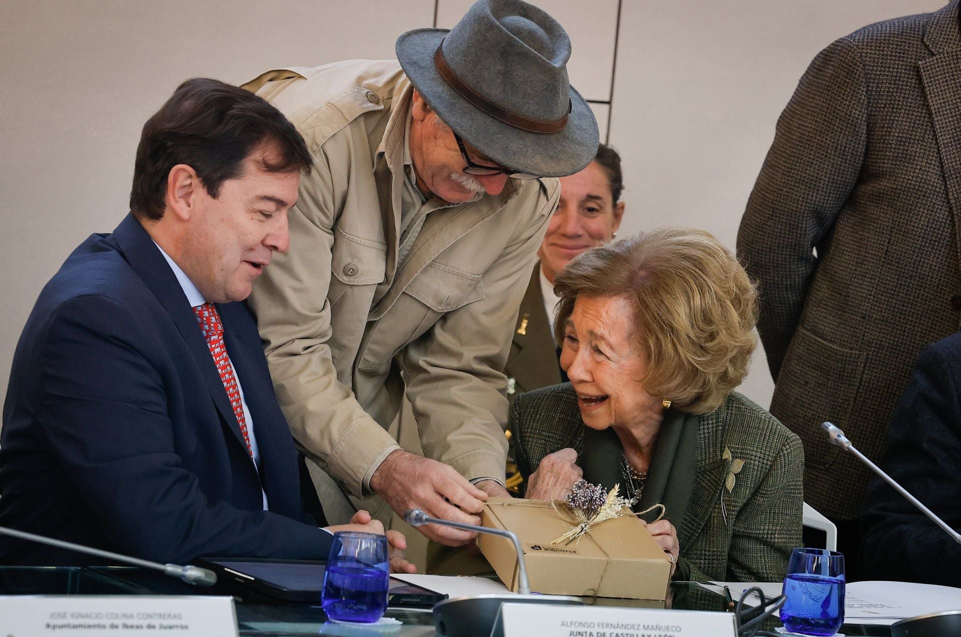 Eudald Carbonell entrega a doña Sofía un ejemplar de la edición 'Sierra de Atapuerca. Una mirada botánica' en presencia de Fernández Mañueco.