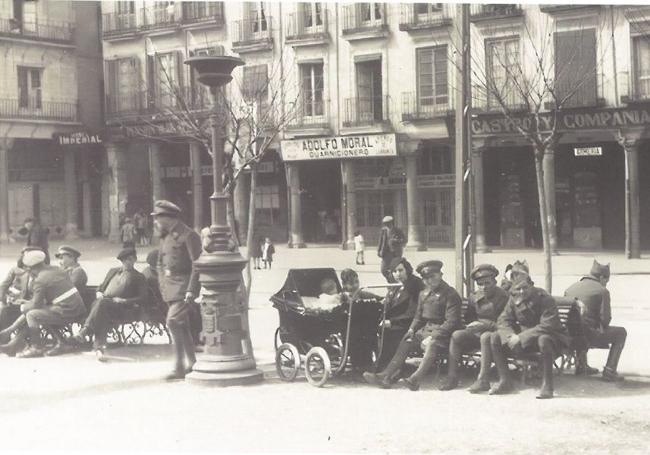 Hombres de uniforme y vida cotidiana en la Plaza Mayor.