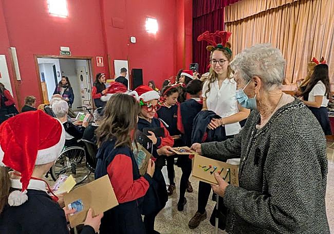 Carmen Sampedro, una de las residentes, intercambiando postales navideñas con los niños