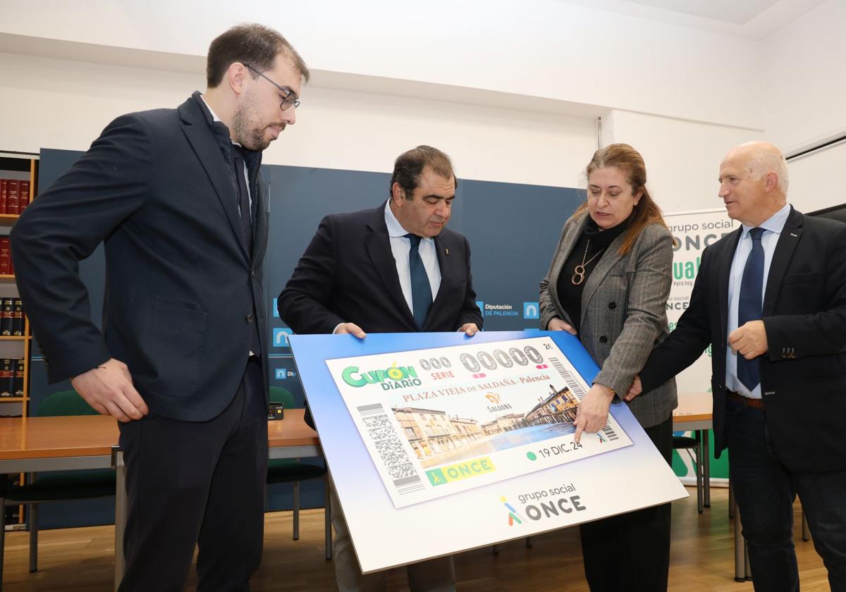 Araceli de las Heras, presidenta territorial de la ONCE en Castilla y León, muestra el cupón al alcalde de Saldaña, Adolfo Palacios, junto con el vicepresidente territorial (Rodrigo Gonzalo) y al diputado Urbano Alonso.