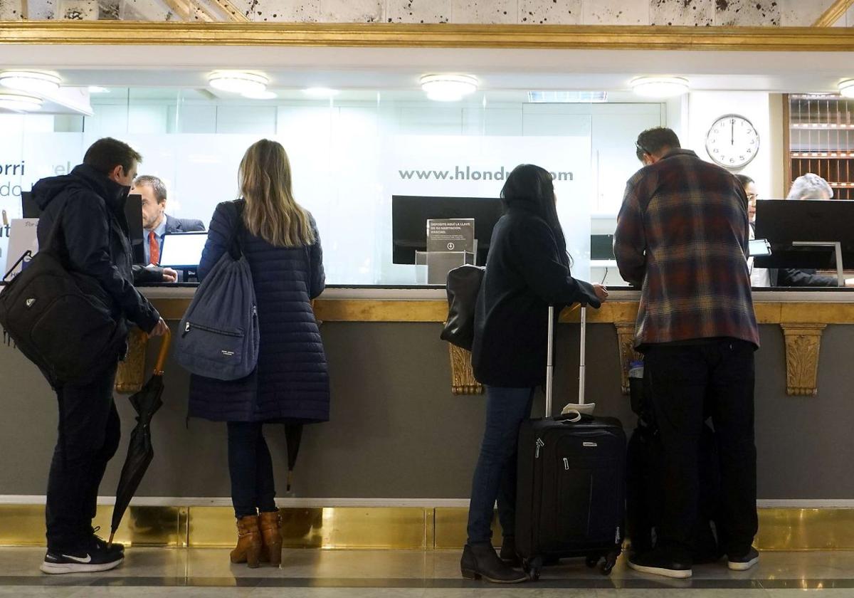 Tturistas hacen el 'check-in' en un hotel.