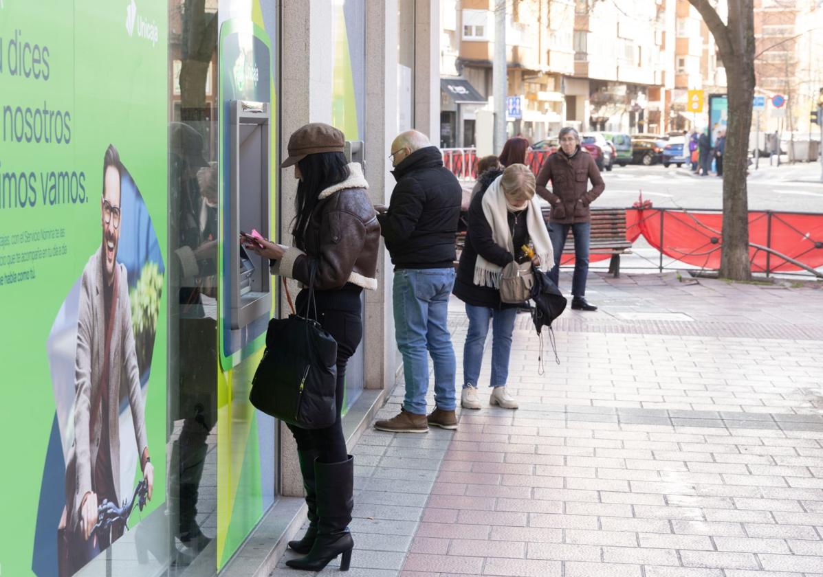 Varios ciudadanos sacan efectivo de los cajeros automáticos de la calle Cerrada de Valladolid este viernes.