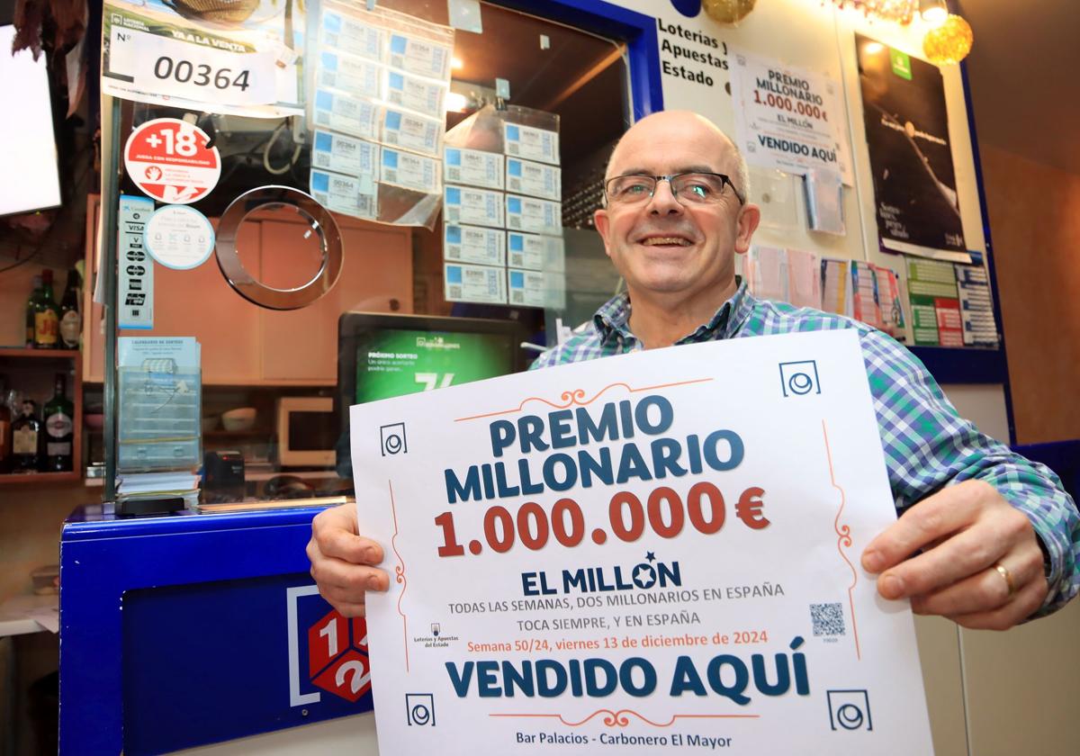 El dueño del bar Palacio en Carbonero el Mayor, Alberto Galán, muestra el cartel que ha recibido este sábado por la mañana en el que acredita la venta del boleto ganador de 'El Millón' del Euromillones.