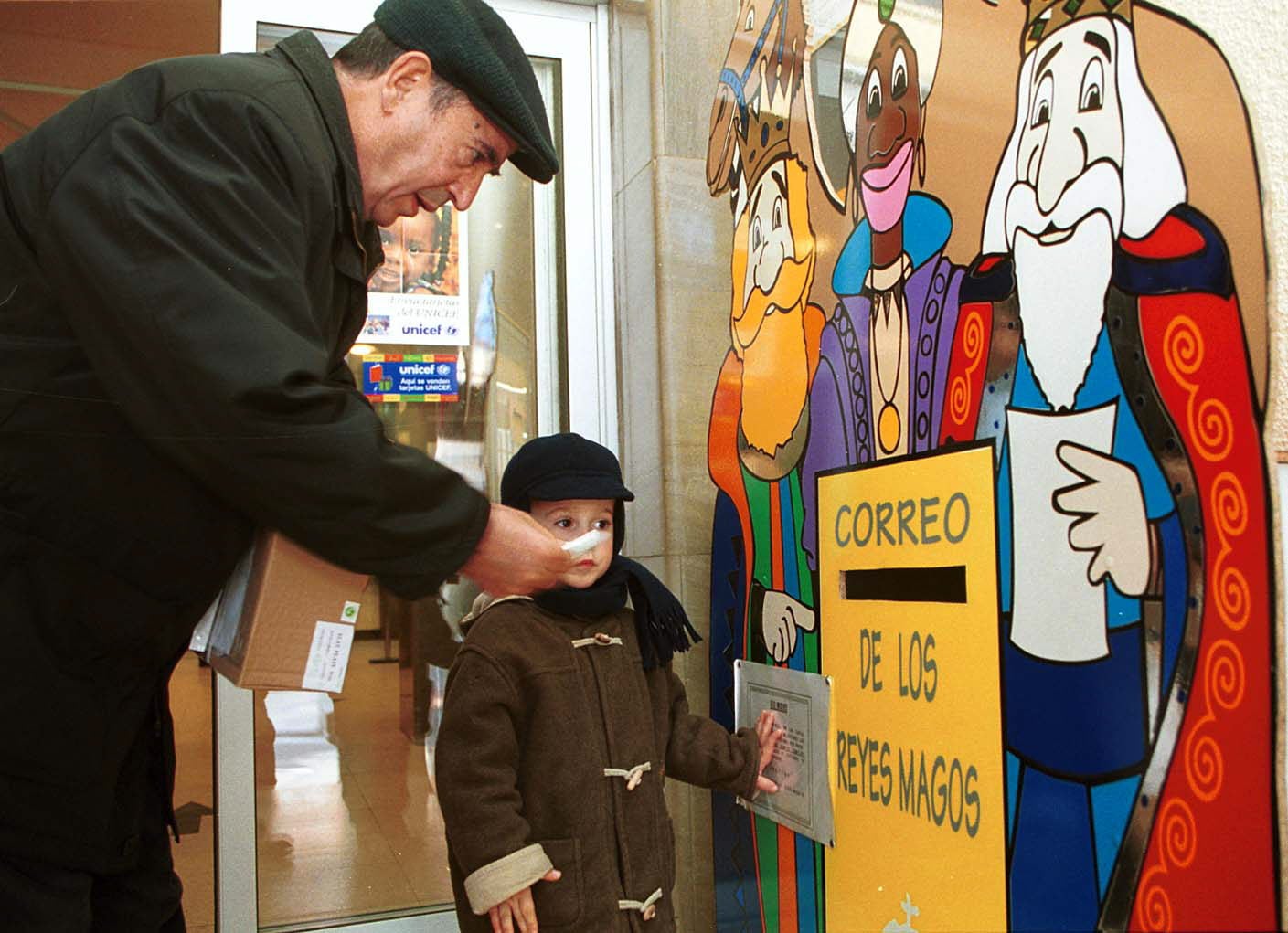 Un niño deposita su carta para los Reyes Magos en el buzón instalado en Correos. 21 de diciembre de 2000.