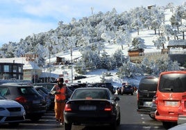 Un coche busca aparcamiento en el parking de Navacerrada, que este fin de semana ha estado prácticamente lleno