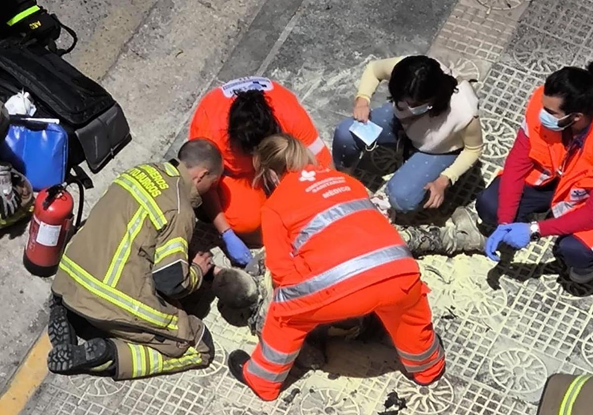 Bomberos y sanitarios de Burgos atienden al hombre quemado en la calle en mayo de este año.