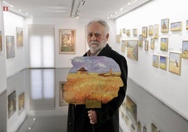 Pascual Aranda en la sala rodeado de sus pinturas.