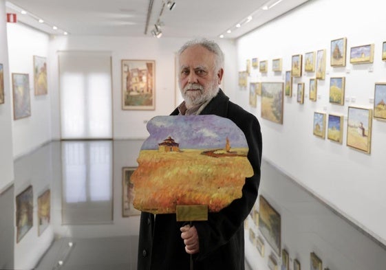 Pascual Aranda en la sala rodeado de sus pinturas.