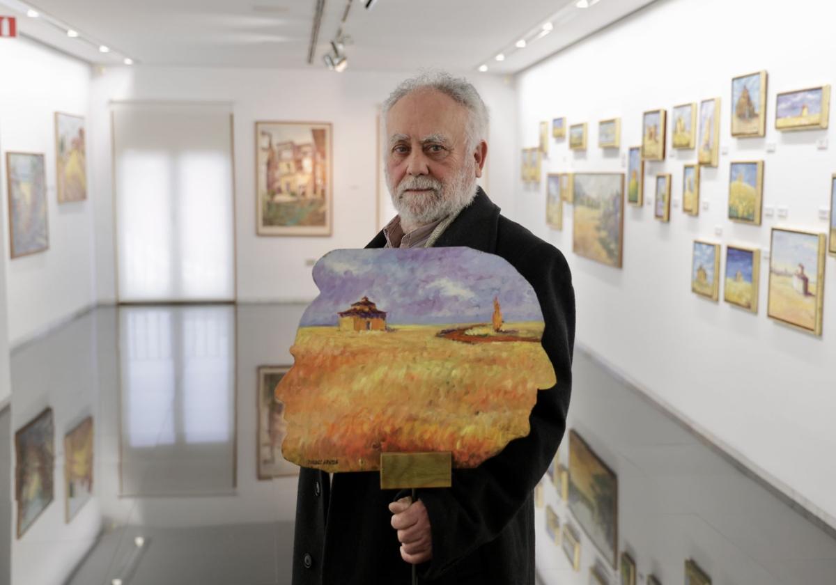 Pascual Aranda en la sala rodeado de sus pinturas.