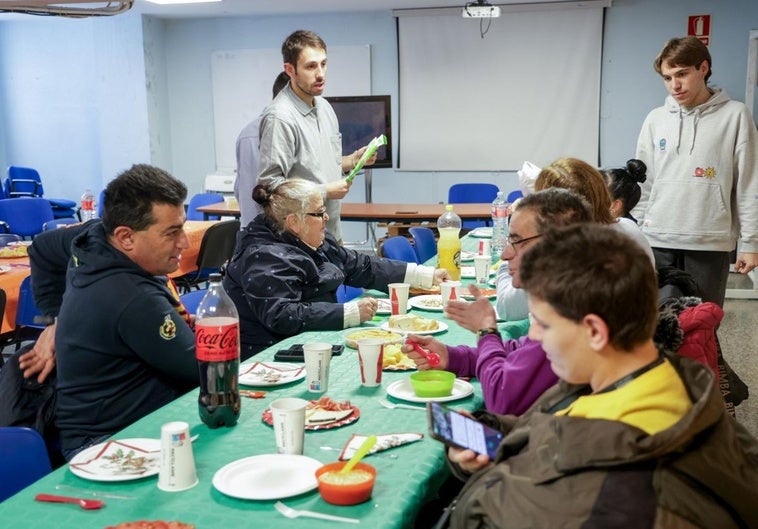 Voluntarios del Consejo de la Juventud sirven la comida solidaria en su sede de la calle San Blas.