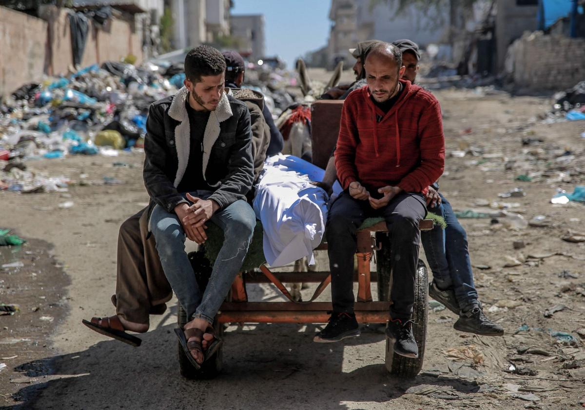 El cuerpo de un palestino muerto por las tropas israelíes es transportado en un carro tirado por un burro.