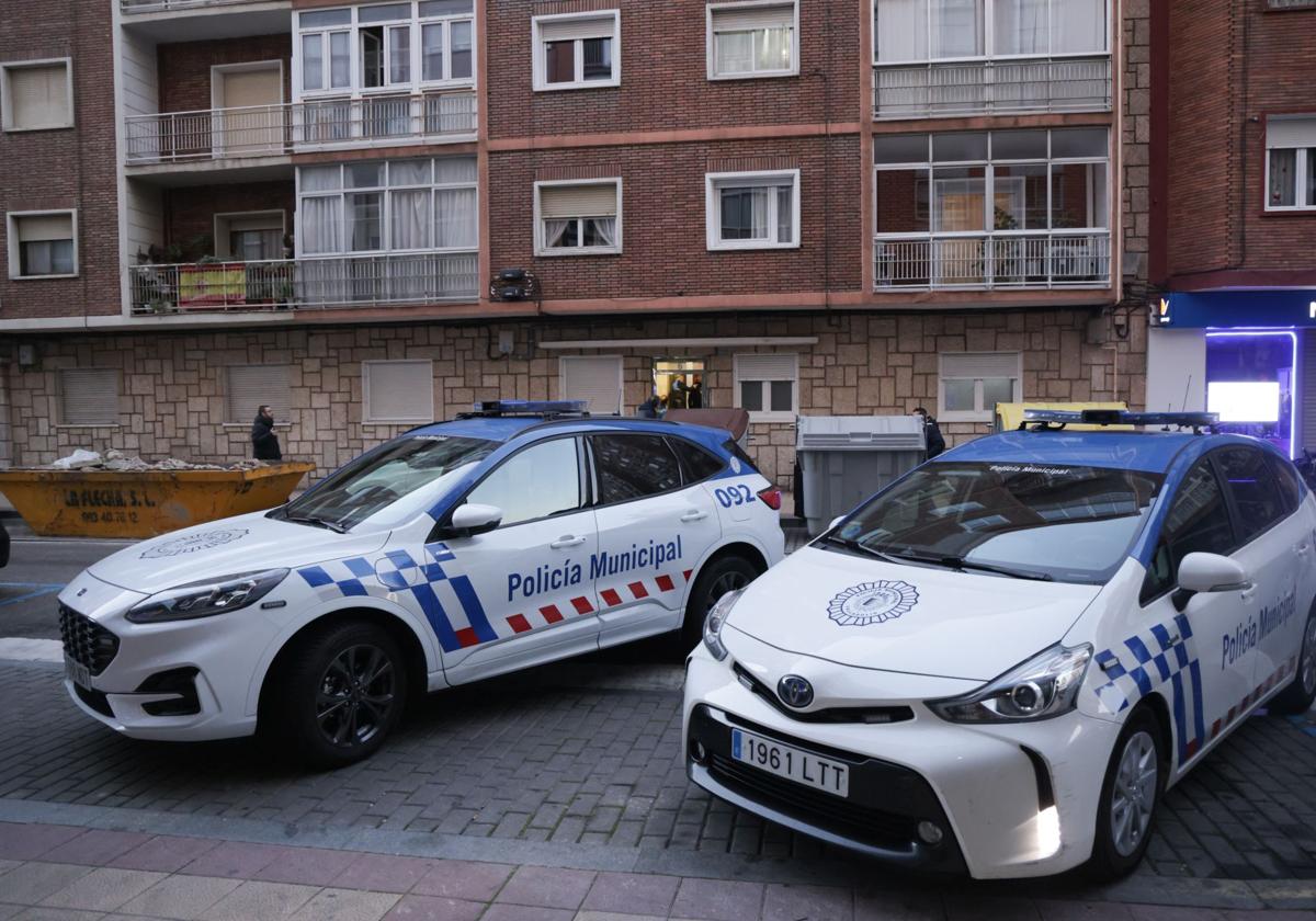 Dos vehículos de la Policía Municipal, frente al portal del edificio en el que ocurrieron los hechos.