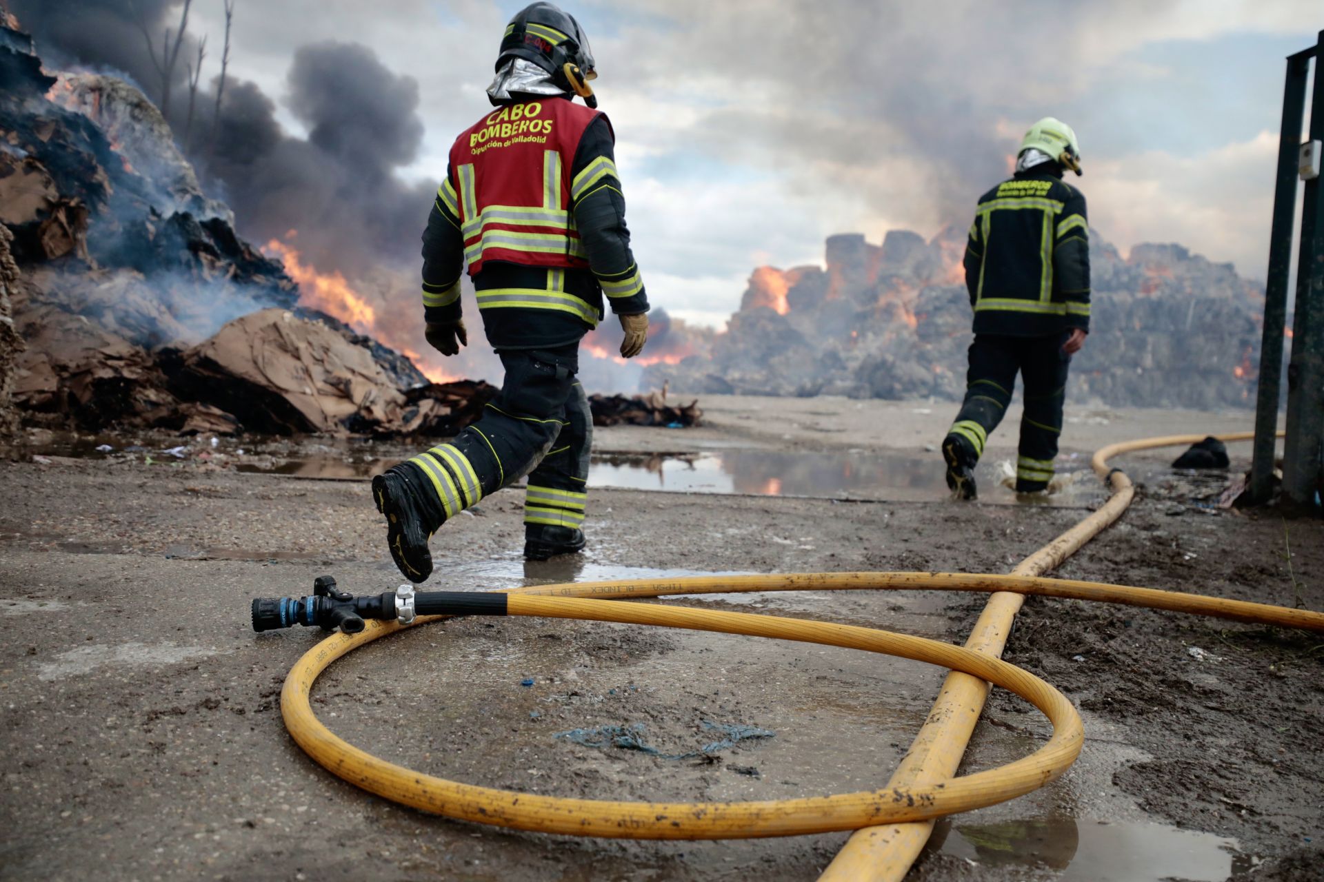 El problema llega cuando el fuego se descontrola. De ahí el horror de los incendios forestales. De ahí los daños como los que el 16 de mayo sufrió una fábrica de reciclaje en Aldeamayor. Los restos del incendio pueden verse, entre humo, al fondo. La manguera, como una serpiente agotada, descansa mientras los bomberos dan por finalizada la primera fase de su labor. 