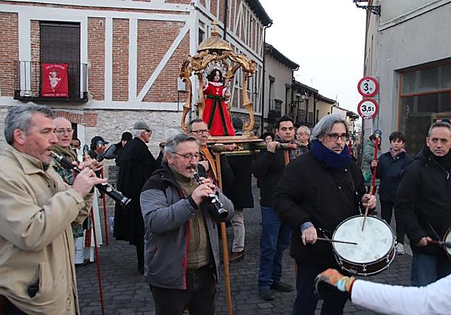 Multitud de personas y músicos acompañan al Niño de la Bola en procesión.