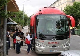 Multitud de personas hacen cola para subir a un autobús en dirección Madrid.