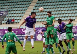 Lance de cabeza entre la defensa del Atlético Astorga y la delantera del Palencia CF.