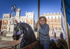 Un niño disfruta montado en un caballito del Tiovivo 1900