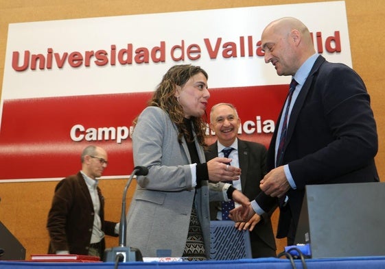 Sonia Ortega se saluda con el vicerrector del campus de Palencia, Julio Diez Casero, ante la mirada del rector de la UVA, Antonio Largo, este lunes en La Yutera.