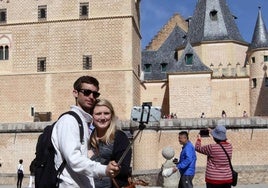 Unos turistas se hacen unas fotos ante el Alcázar de Segovia.