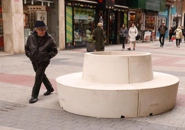 Un viandante observa los bancos recién instalados en calle Mantería.