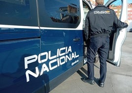 Un agente de la Nacional accede al vehículo policial.