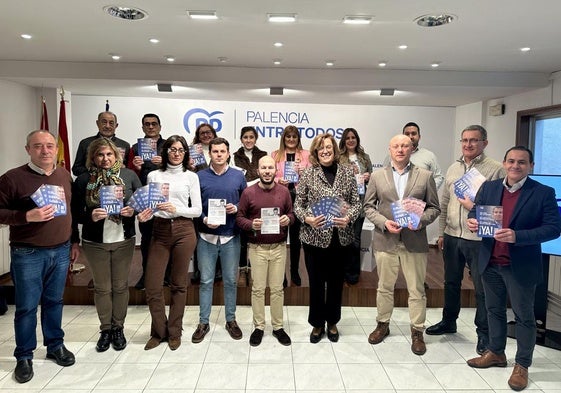 Los dirigentes del PP posan en la sede con un folleto informativo.