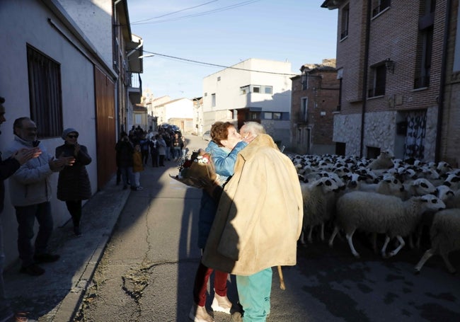 Asunción Alonso, esposa de Antonio, da un abrazo a su marido, quien es aplaudido por sus vecinos en la Calle Mayor.